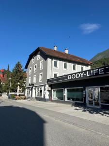 a building on a street with a body life store at Gemütliches Apartment in Landeck in Landeck +5 photos
