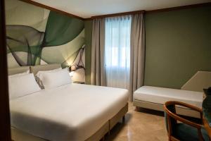 a hotel room with two beds and a window at Spazio Origine - Studio Hotel in Monopoli