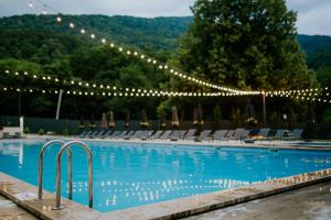 a large swimming pool with lights and chairs at Reserve Resort Lagodekhi in Lagodekhi