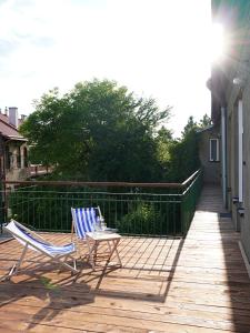 two chairs and a table on a deck at ENKLAWA Apartamenty in Przemyśl