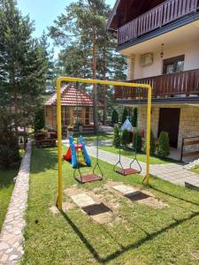 a playground in a yard next to a house at Tara Saric Duplex in Kaludjerske Bare