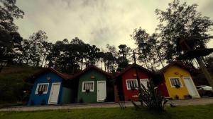 a row of houses painted in different colors at Chale Azul Aconchegante com lareira no bosque e estacionamento grátis in Extrema