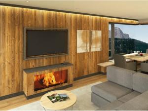a living room with a fireplace and a television at App. Sun Burdengeja in Selva di Val Gardena