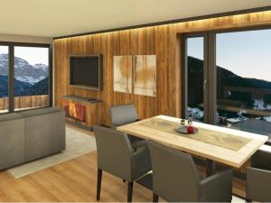 a dining room with a table and chairs and a television at App. Sun Burdengeja in Selva di Val Gardena