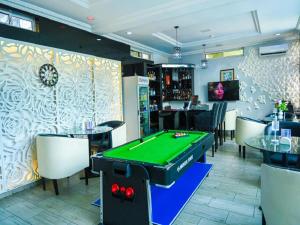 a pool table in a room with tables and chairs at Parkview Astoria Hotel in Lagos