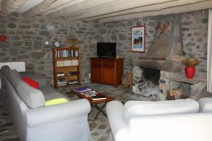 a living room with two couches and a stone fireplace at La Maison De Suzanne in Arcomie