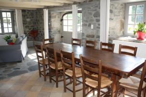 a dining room with a wooden table and chairs at La Maison De Suzanne in Arcomie