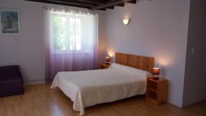a bedroom with a bed and a window with two lights at La Maison De Suzanne in Arcomie