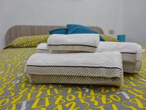 a pile of towels sitting on top of a bed at Maison Vivian Apartment in Marzamemi