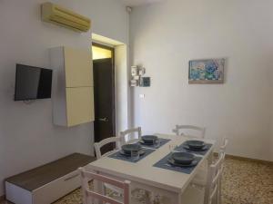 a dining room with a white table and chairs at Maison Vivian Apartment in Marzamemi