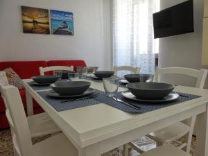 a dining room table with bowls and plates on it at Maison Vivian Apartment in Marzamemi