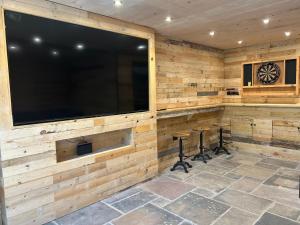 a room with a large television and two stools at Pingle Nook Barn on the Farm - Denby Dale in Huddersfield