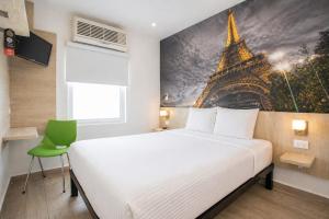 a bedroom with a bed and a painting of the eiffel tower at Hi! Monterrey Aeropuerto in Monterrey