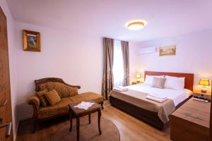 a hotel room with a bed and a chair at Gegë Boutique Hotel in Gjakove