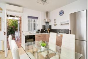 a kitchen with a glass table and a stainless steel refrigerator at Casa Trino in Almuñécar