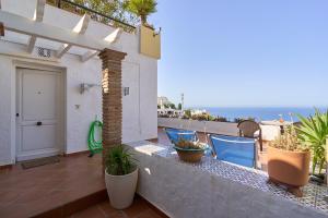a balcony with chairs and a door and the ocean at Casa Trino in Almuñécar