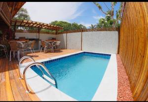 a swimming pool in a backyard with a table and chairs at Flat Vila Taipu in Marau