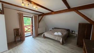 a bedroom with a bed and a large window at Agroturystyka Folwark Natura in Wleń