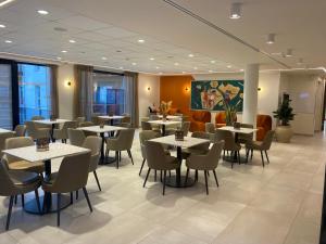 a restaurant with tables and chairs in a room at DOMITYS - Les Ambres in Cognac