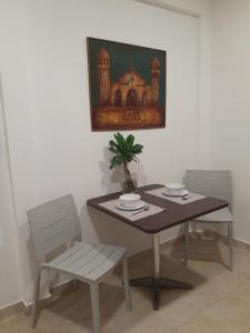 a table with two chairs and a table with a plant on it at Charlys Place in San Salvador