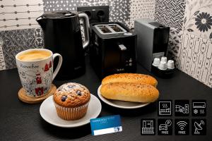 a table with a cupcake and muffins and a coffee at ENJOYHARRACHOV - Atraktivní slunný klimatizovaný apartmán 24 v centru Harrachova s velkou terasou, saunou, parkováním, Wifi-WLAN, SAT, herní konzolí, Netflix zdarma a možností dobíjení auta jen 150m od lanovky in Harrachov
