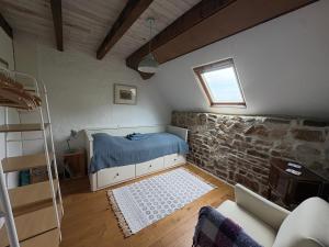 a bedroom with a bed and a brick wall at Le petit Valet in Saint-Clément