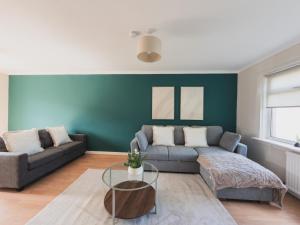 a living room with a couch and a table at The Cosy Plover in Johnstone