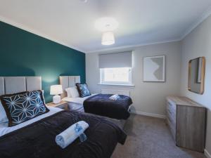 a hotel room with two beds and a window at The Cosy Plover in Johnstone +12 photos