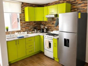 a kitchen with lime green cabinets and a refrigerator at Casa Cholula in La Concepción
