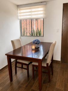 a wooden dining room table with chairs and a window at Casa Cholula in La Concepción +1 photo