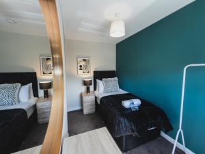 a small bedroom with a bed and a mirror at The Cosy Plover in Johnstone