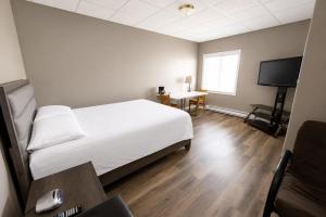 a bedroom with a bed and a desk and a television at Hotel Blanc-Sablon in Blanc-Sablon +9 photos