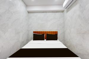 two black pillows sitting on a bed in a room at Hotel O Lotus in Surat