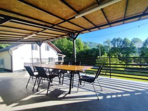 a wooden table and chairs on a patio at CasaNatur in Leordina