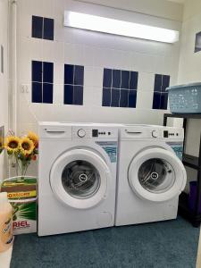 two washing machines are in a laundry room at Gästehaus Rheinstetten Forchheim in Rheinstetten +14 photos