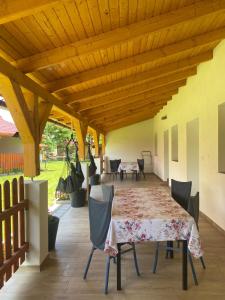 a patio with a table and chairs under a wooden ceiling at Csillagfürt Vendégház in Kiskunmajsa