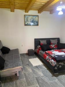 a living room with a couch and a bed at Csillagfürt Vendégház in Kiskunmajsa