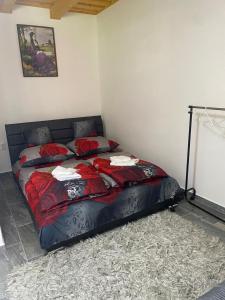 a bedroom with a bed with red sheets on it at Csillagfürt Vendégház in Kiskunmajsa