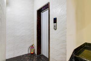 a bathroom with a mirror and a fire extinguisher at Hotel O MAJESTIC M2 INN in New Town