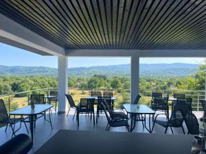 a restaurant with tables and chairs and a view of the mountains at ALLIANCE Hotel NEW 2025 -Breakfast and pool included in Solotvyno