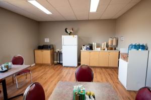 a room with white refrigerators and tables and chairs at Hotel Blanc-Sablon in Blanc-Sablon