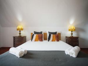 a bedroom with a large white bed with towels on it at Akisol Hostel Idanha in Idanha-a-Nova