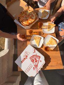 a group of people sitting around a table eating pizza at Mountain View in Vyshkove