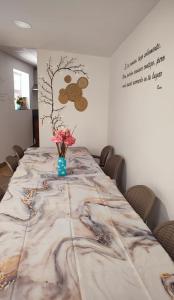 a long table with a vase of flowers on it at Albergue Vía Vitae in Otur +14 photos