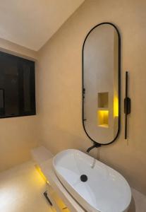 a bathroom with a white sink and a mirror at Maxx Una in Unawatuna