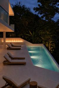 a swimming pool with lounge chairs next to a house at Maxx Una in Unawatuna +3 photos