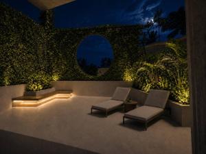 a patio with two chairs and lights at night at Maxx Una in Unawatuna
