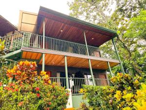 a large building with a balcony and trees at Tabulia Tree Hotel and Villas in Manuel Antonio