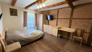 a bedroom with a bed and a desk and a television at Agroturystyka Folwark Natura in Wleń