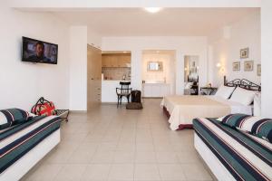 a hotel room with two beds and a kitchen at 9 Muses in Andros